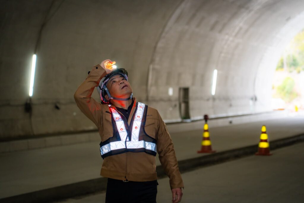 トンネルで上を見上げて確認するスタッフ